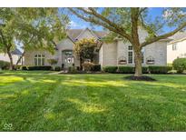 Stately white brick home with meticulously maintained lawn and mature trees at 13499 Marjac Way, Fishers, IN 46055