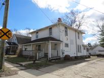 Two-story home featuring a front porch and a classic, timeless facade, on a partially sunny day at 159 E Washington St, Morgantown, IN 46160