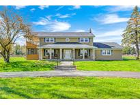Inviting two-story home featuring a spacious front yard with beautiful landscaping and inviting front porch at 2141 E County Road 200 N, Danville, IN 46122