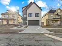 Charming two-story home featuring modern design, neutral siding, black trim, and a spacious driveway at 2406 Carrollton Ave, Indianapolis, IN 46205