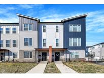 New townhouse exteriors feature blue and gray siding, front porches, concrete walkways and professionally landscaped yards at 3046 W New York St, Indianapolis, IN 46222