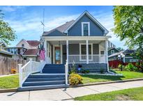 Charming two-story home featuring a welcoming front porch, beautiful landscaping, and gray exterior paint at 505 W Washington St, Shelbyville, IN 46176