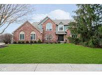 Charming two-story brick home with a well-manicured lawn and professionally landscaped front yard at 5109 Kingswood Dr, Carmel, IN 46033