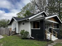 Charming home featuring gray siding, black brick accents, and a cozy front porch at 744 Wallace Ave, Indianapolis, IN 46201