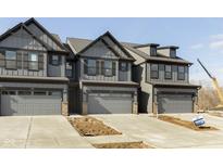 Modern townhome exterior showcasing neutral color palette and attached two car garage in a new construction community at 9742 Behner Dr, Fishers, IN 46250