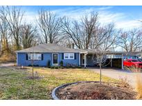 Charming single-story home with blue siding, landscaped yard, and carport at 1195 W Edgewood Ave, Indianapolis, IN 46217