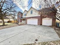 Two-story brick and vinyl home boasts an attached two-car garage and concrete driveway at 1470 Northern Valley Trl, Avon, IN 46123