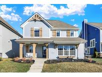 Charming two-story home with a light blue exterior, decorative shutters, and a welcoming front porch at 15297 Fairlands Dr, Westfield, IN 46074