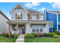 Charming two-story home featuring a welcoming front porch, beautiful landscaping, and a well-manicured lawn at 15297 Fairlands Dr, Westfield, IN 46074