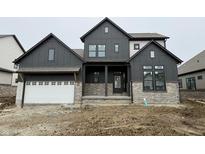 Modern two-story home with a dark gray exterior, stone accents, and a two-car garage at 19854 Chatham Shore Ln, Westfield, IN 46074