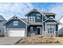 Charming two-story home featuring a blue facade, white trim, stone accents, and an attached two-car garage at 19854 Chatham Shore Ln, Westfield, IN 46074