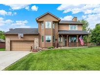 Charming two-story home featuring a well-manicured lawn, a covered porch with an American flag, and an attached two-car garage at 211 Deborah Ln, Whiteland, IN 46184