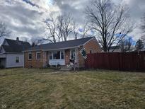 Charming brick ranch home featuring a well-maintained lawn and inviting front porch at 2113 Silver St, Anderson, IN 46012