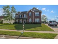 Charming two-story home boasts a manicured lawn, brick facade, and well-maintained landscaping at 254 Halldale Dr, Whiteland, IN 46184