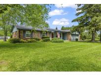 Charming single-story brick home featuring a well-manicured lawn, mature trees, and an attached two-car garage at 2818 S Irwin St, Indianapolis, IN 46203
