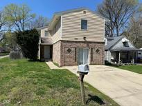 Two-story home with brick and siding, a well-manicured lawn, and a paved driveway leading up to the house at 3060 S Lyons Ave, Indianapolis, IN 46241