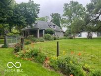 Charming home with a well-manicured front yard, lovely flower beds, and a detached two-car garage at 5533 Wilson Way, Jamestown, IN 46147