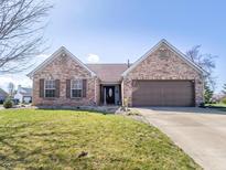 Charming brick home featuring a two-car garage, well-manicured lawn and lovely curb appeal at 7425 Monterey Cir, Avon, IN 46123