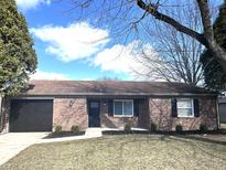 Charming brick home featuring a well-maintained front yard and an attached garage at 7807 Inverness Dr, Indianapolis, IN 46237
