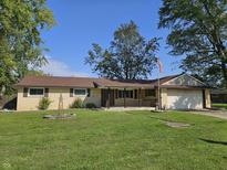 Charming single-story home with a well-maintained lawn, porch, and attached two car garage at 812 Madison St, Frankton, IN 46044