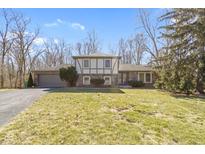 Charming two-story home featuring a two-car garage, a well-manicured lawn, and mature trees at 8831 Lincolncreek Cir, Indianapolis, IN 46234