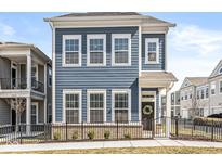 Charming blue two-story home featuring a welcoming front door with a decorative wreath and a neat, fenced yard at 1004 Astor Ln, Carmel, IN 46032