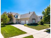 Charming two-story brick home with well-manicured lawn and inviting driveway, under a clear blue sky at 12067 Edgefield Dr, Fishers, IN 46037