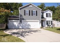 Charming two-story home with grey vinyl siding, white brick accents, and a spacious driveway at 12128 Princewood Ct, Fishers, IN 46037