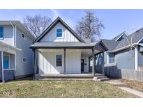 Charming home featuring gray trim, vertical siding, and a cozy covered front porch at 1434 S Talbott St, Indianapolis, IN 46225