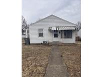 Charming single story home with white siding, front awning, and concrete walkway at 1843 Bauer Rd, Indianapolis, IN 46218