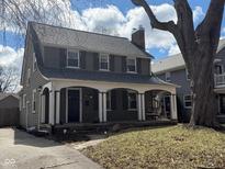 Charming two-story home with a welcoming front porch, dark shutters and a beautifully maintained lawn at 207 Blue Ridge Rd, Indianapolis, IN 46208