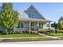 Inviting home with a covered porch, well-manicured lawn, and mature landscaping at 2274 Finchley Rd, Carmel, IN 46032