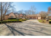 Beautiful brick home featuring an attached three-car garage, inviting curb appeal, and a circular driveway at 2688 S Oscar Ct, Morgantown, IN 46160