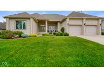 Well-manicured front lawn and exterior of home with 3-car garage and mature landscaping at 286 S Woodridge Dr, Pittsboro, IN 46167