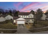 Charming two-story home featuring a front porch, attached garage, and well-manicured lawn at dusk at 3649 Homestead W Cir, Plainfield, IN 46168