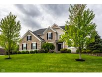 Beautiful two-story brick home with a well-manicured lawn and mature trees at 3905 Pelham Rd, Carmel, IN 46074