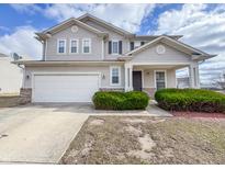 Charming two-story home featuring a covered entryway, attached garage, and well-maintained landscaping at 3941 Planewood Dr, Indianapolis, IN 46235