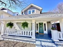 Charming home with a covered front porch featuring hanging ferns and a decorative green front door at 4224 Cornelius Ave, Indianapolis, IN 46208