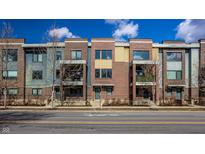 Attractive townhomes feature brick and siding exteriors, with small balconies under a partly cloudy sky at 606 E 10Th St, Indianapolis, IN 46202