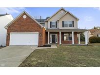 Charming two-story home with a two-car garage, brick accents, and inviting front porch at 6311 Feather Run Dr, Indianapolis, IN 46237