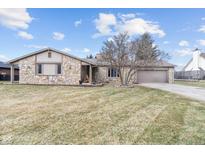 Charming stone home with an attached garage, mature landscaping and a cozy front porch seating area at 6412 Lava Ct, Indianapolis, IN 46237