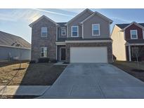 Two-story home featuring a brick and siding facade, attached two-car garage, and a well-maintained lawn at 6610 Trey Ct, Camby, IN 46113