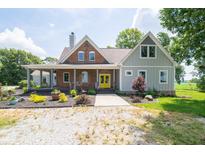 Charming home featuring a mix of brick and siding, a cozy front porch and a bright, yellow front door at 695 N 650 W, Lebanon, IN 46052