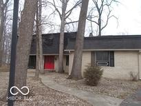 Charming brick home with a red front door and mature trees in a quiet neighborhood at 7240 W Glendale Ln, Greenfield, IN 46140