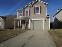 Inviting two-story home with neutral siding, red shutters, well-maintained landscaping, and attached garage at 8848 Hosta Way, Camby, IN 46113
