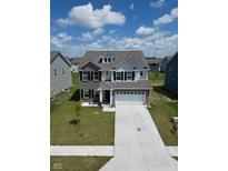 Charming two-story home featuring a two-car garage, dormer windows, and well-manicured landscaping at 10202 Meadow Path Ln, Indianapolis, IN 46239