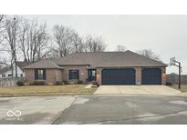 Charming brick ranch-style home with an attached two-car garage and well-manicured landscaping at 1050 Lapwing Ct, Columbus, IN 47203