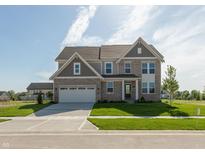 Two-story brick home featuring an attached two-car garage and a well-manicured front yard at 1101 Knoll Ct, Greenwood, IN 46143