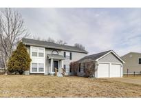 Charming two-story home with gray siding, a well-manicured lawn, and an attached two-car garage at 11410 Dunshire Dr, Indianapolis, IN 46229