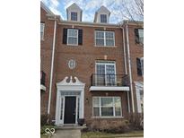 Charming brick townhouse featuring black door, balcony and dormer windows at 11569 Reagan Dr, Fishers, IN 46038